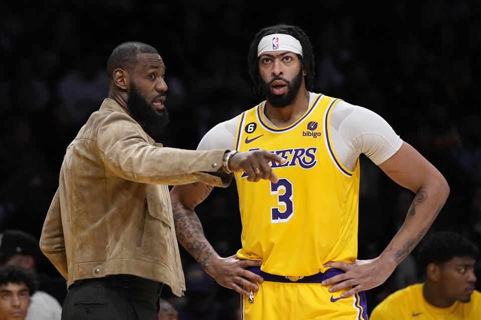 Los Angeles Lakers' LeBron James, left, talks with forward Anthony Davis during the second half of an NBA basketball game against the Phoenix Suns Wednesday, March 22, 2023, in Los Angeles. (AP Photo/Mark J. Terrill)