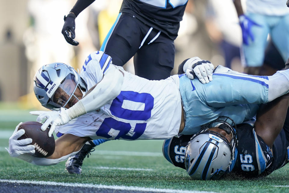 Dallas Cowboys running back Tony Pollard scores past Carolina Panthers defensive tackle Derrick Brown during the second half of an NFL football game Sunday, Nov. 19, 2023, in Charlotte, N.C. (AP Photo/Erik Verduzco)