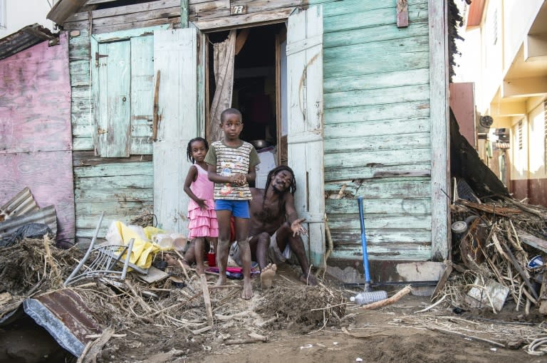 A family stand outside their house in Roseau, on the Caribbean island of Dominica after Hurricane Maria hit the island