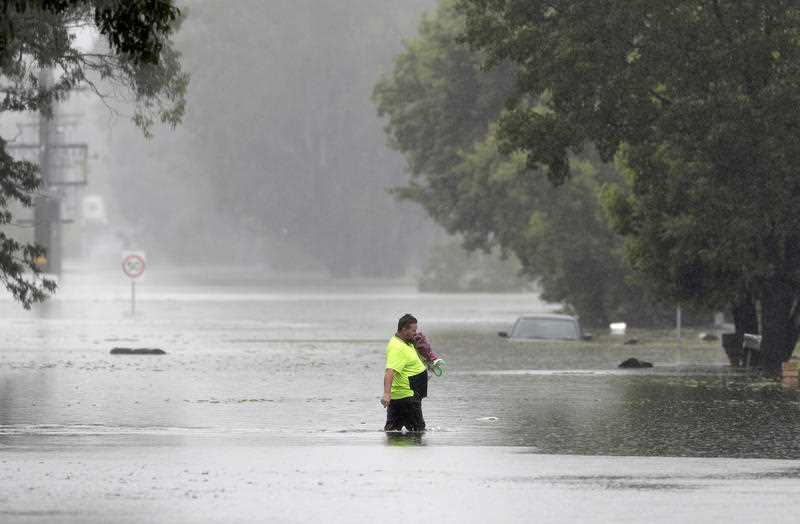 A man walks across a flooded street in Windsor, northwest of Sydney.