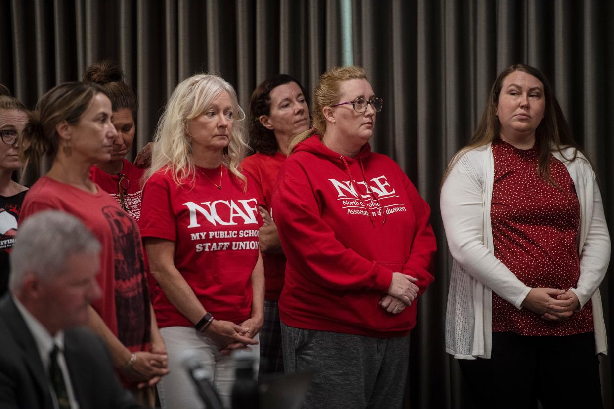 Area teachers stand behind Soren Pedersen as he speaks to Buncombe County Commissioners about raising teacher pay, October 3, 2023.