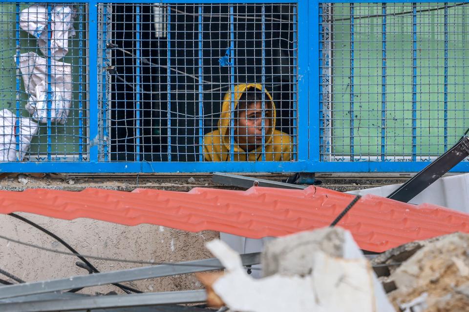 A Palestinian youth looks on from a U.N. school where displaced people take shelter after an Israeli strike hit a house nearby, in Rafah in the southern Gaza Strip on Dec. 21, 2023, amid continuing battles between Israel and the militant group Hamas.