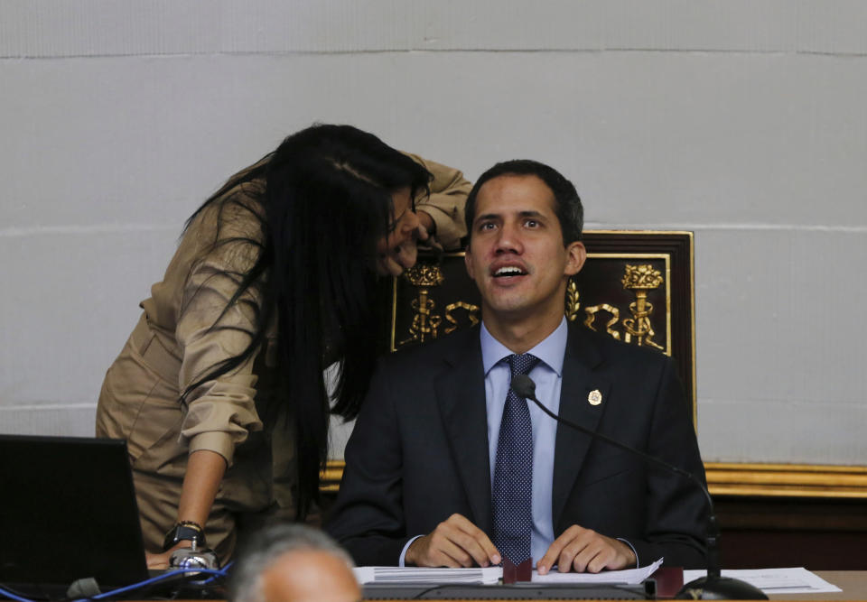 Juan Guaido, right, President of National Assembly and self-proclaimed interim president speaks with lawmaker Delsa Solorzano during a session of the National Assembly in Caracas, Venezuela, Tuesday, April 2, 2019. Venezuela's chief justice on Monday asked lawmakers of the rival pro-government National Constituent Assembly to strip Guaido of his parliamentary immunity, taking a step toward prosecuting him for alleged crimes as he seeks to oust President Nicolas Maduro. (AP Photo/Fernando Llano)