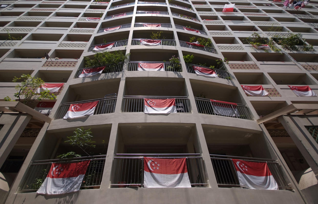 Singapore's national flags are displayed from an apartment block during National Day in central Singapore August 9, 2011. Singapore celebrates its 46th National Day on Tuesday, with its economy likely to expand by five to six percent this year, Prime Minister Lee Hsien Loong said on August 8, 2011, indicating the government now expects growth to come in at the lower end of its five to seven percent forecast.   REUTERS/Kevin Lam (SINGAPORE - Tags: SOCIETY ANNIVERSARY)