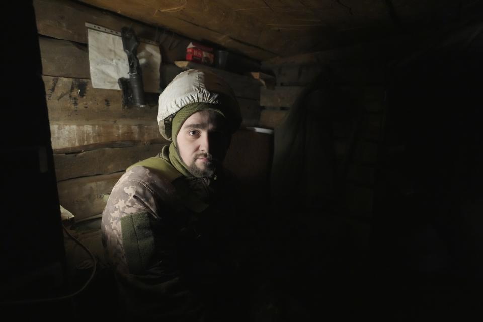 A Ukrainian serviceman looks at a photographer while resting in a shelter on the front line in the Luhansk region, eastern Ukraine, Friday, Jan. 28, 2022. High-stakes diplomacy continued on Friday in a bid to avert a war in Eastern Europe. The urgent efforts come as 100,000 Russian troops are massed near Ukraine's border and the Biden administration worries that Russian President Vladimir Putin will mount some sort of invasion within weeks. (AP Photo/Vadim Ghirda)