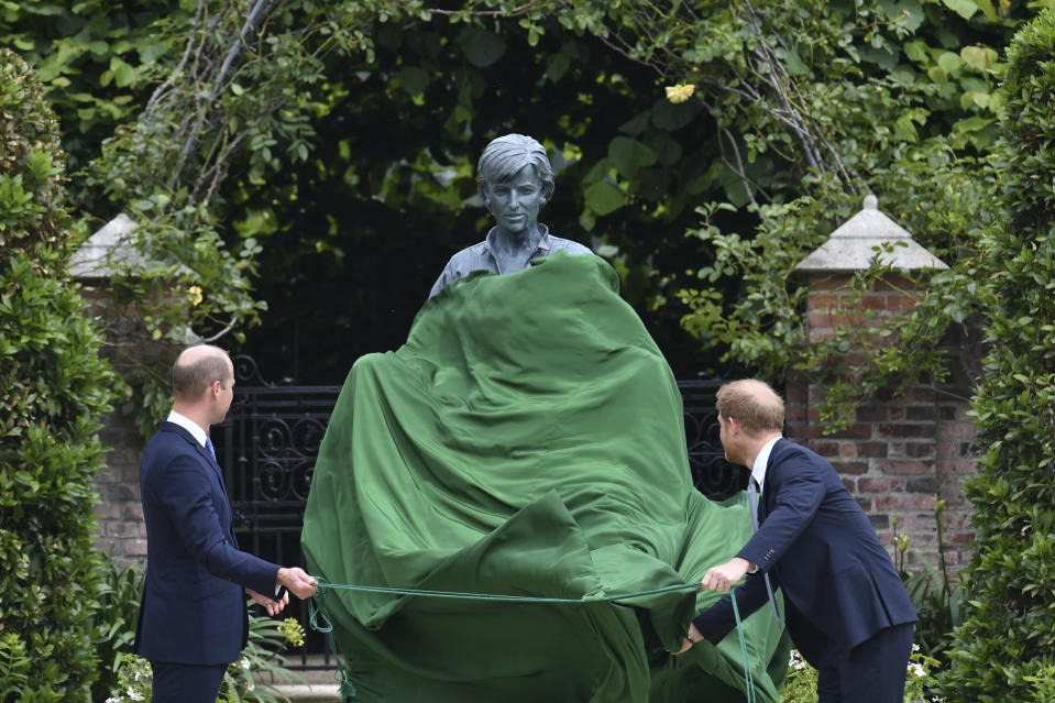 El príncipe Guillermo de Inglaterra, a la izquierda, y su hermano, el príncipe Enrique, develan una estatua que encargaron de su madre, la princesa Diana, en el que habría sido su 60 cumpleaños, el jueves 1 de julio de 2021 en el Jardín Hundido del Palacio de Kensington, en Londres. (Dominic Lipinski /Pool Photo via AP)