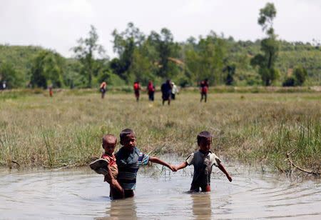 Rohingya children make their way through water as they try to come to the Bangladesh side from No Man’s Land after a gunshot being heard on the Myanmar side, in Cox’s Bazar, Bangladesh August 28, 2017. REUTERS/Mohammad Ponir Hossain