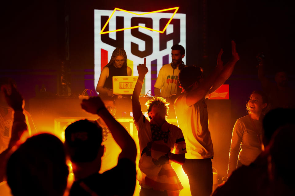 People dance during an official U.S. Soccer fan party at the Budweiser World Club ahead of a FIFA World Cup group B soccer match between the United States and Wales, in Doha, Sunday, Nov. 20, 2022. (AP Photo/Ashley Landis)