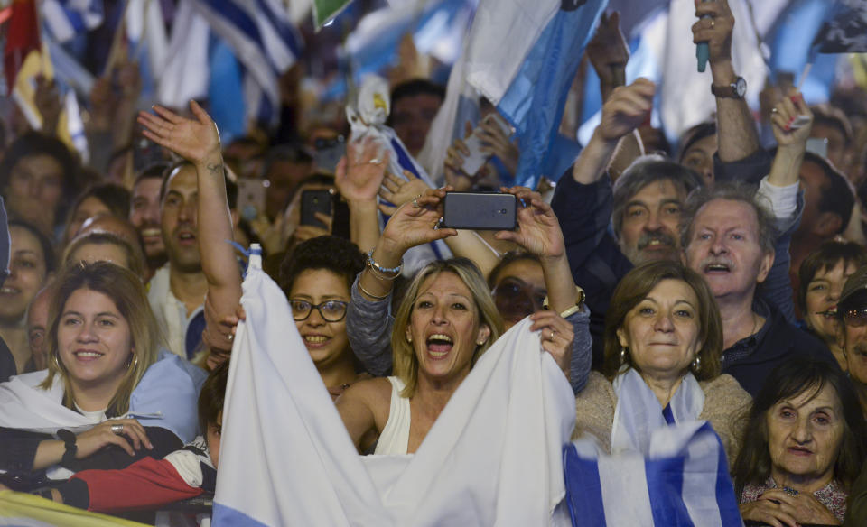 Supporters of opposition presidential candidate Luis Lacalle Pou react at the party's headquarters as they wait for results after a runoff elections in Montevideo, Uruguay, Sunday, Nov. 24, 2019. Uruguayans are choosing between Presidential candidate for the ruling party Broad Front Daniel Martinez and Lacalle. (AP Photo/Santiago Mazzarovich)