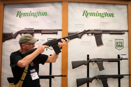 A man aims a Remington firearm at the annual National Rifle Association (NRA) meeting in Dallas, Texas, U.S., May 4, 2018. REUTERS/Adrees Latif