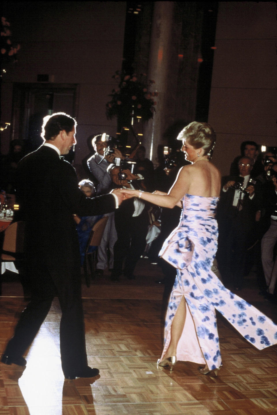 El duque de Cornualles tiende la mano a la madre de sus hijos para bailar. Ocurrió durante una cena en su viaje a Australia en 1988. (Foto: Anwar Hussein / Getty Images)