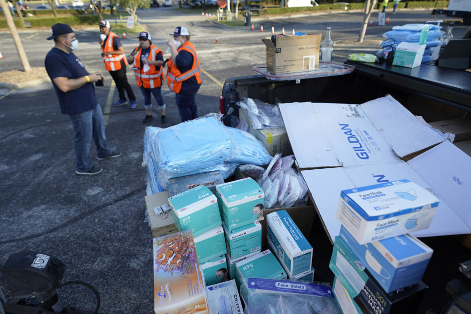 PPE sits on the back of a truck as healthcare workers prepare to open a Texas Division of Emergency Management free COVID-19 testing site at Minute Maid Park Saturday, Aug. 8, 2020, in Houston. The newly opened mega site, which has eight drive-thru lanes and four walk-up lanes, has the ability to process 2,000 tests per day. (AP Photo/David J. Phillip)