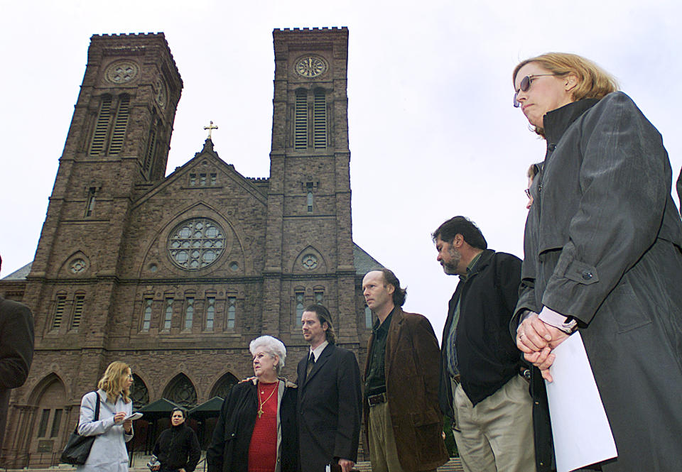 FILE - In this May 9, 2002 file photo, Phyllis Hutnak, right, prepares to speak to the media outside the offices of the Diocese of Providence in Providence, R.I. Hutnak said she was seduced by the late Monsignor Louis Dunn of St. Thomas Church in Providence when she was a teenager. Dunn was listed by the Roman Catholic Diocese of Providence on Monday, July 1, 2019, as one of several members of clergy, religious order priests and deacons who have been credibly accused of sexually abusing children. Dunn died in 2001. (AP Photo/Stew Milne, File)