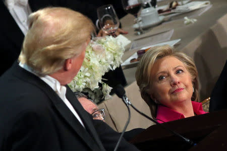Democratic U.S. presidential nominee Hillary Clinton looks at Republican U.S. presidential nominee Donald Trump as he speaks during the Alfred E. Smith Memorial Foundation dinner to benefit Catholic charities in New York, U.S. October 20, 2016. REUTERS/Carlos Barria