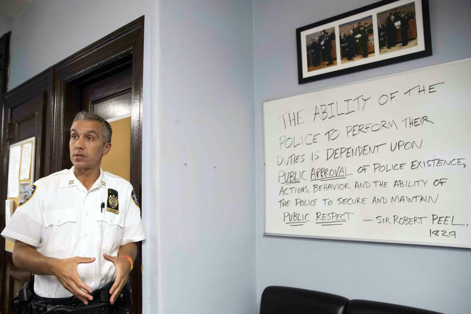 In this Tuesday, June 18, 2019, photo, Capt. Kevin Coleman, commanding officer of the New York City Police Department's 10th Precinct, talks about one of his favorite quotes by Sir Robert Peel during an interview in New York. Coleman has been open throughout his 16-year career about being “a cop who happens to be gay.” (AP Photo/Mary Altaffer)