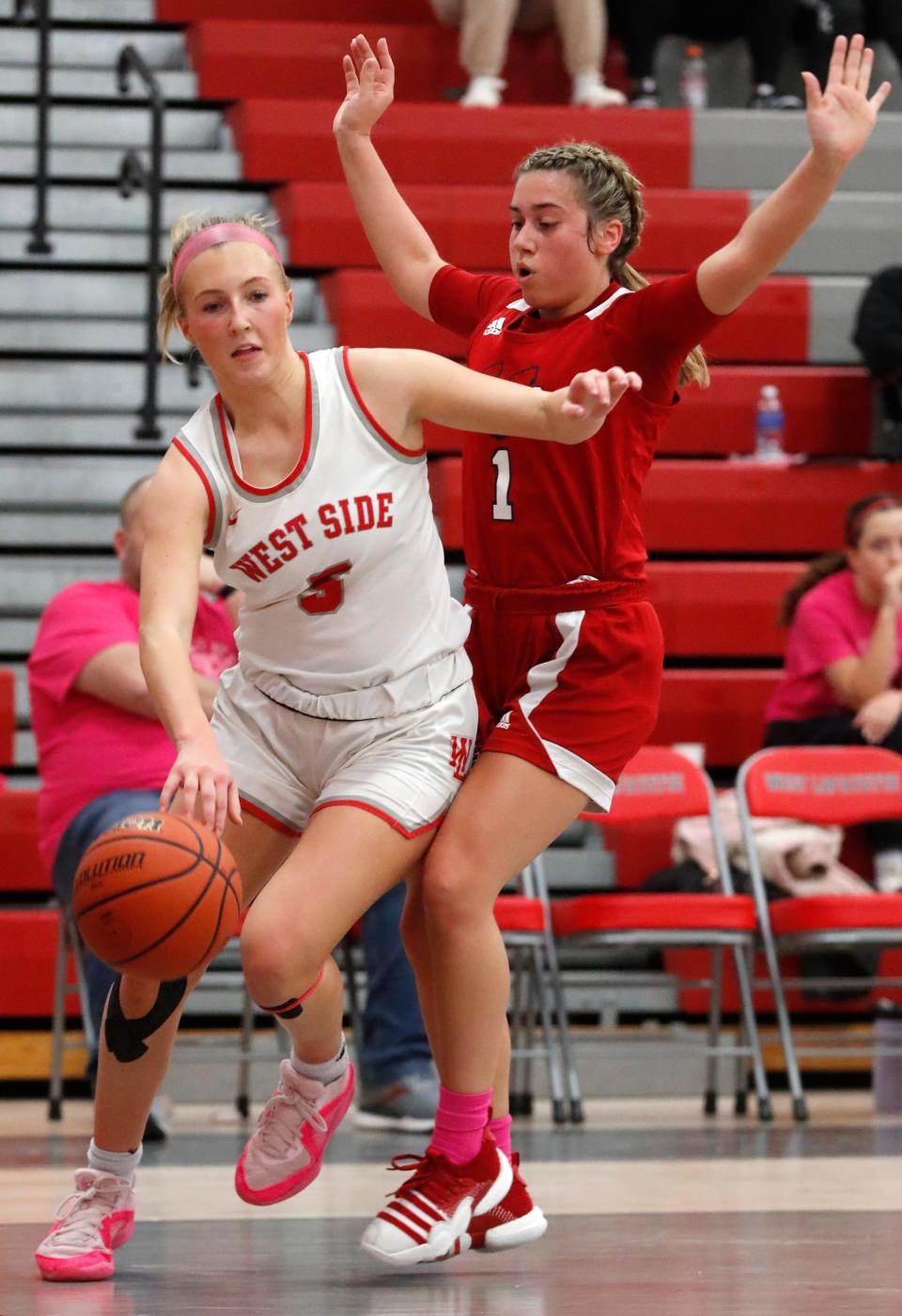 West Lafayette Red Devils guard Dylan Kastens (3) drives past Lafayette Jeff Bronchos Ava Adriano (1) during the IHSAA girl’s basketball game, Tuesday, Jan. 16, 2024, at West Lafayette High School in West Lafayette, Ind. West Lafayette Red Devils won 72-36.