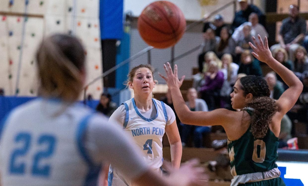 North Penn's Caleigh Sperling (4) passes the ball to teammate Leah Mikulski (22) over Emmaus' Mya Cooper (0) in the first round of the PIAA Class 6A girls’ basketball tournament in Lansdale on Friday, Mar.8, 2024.