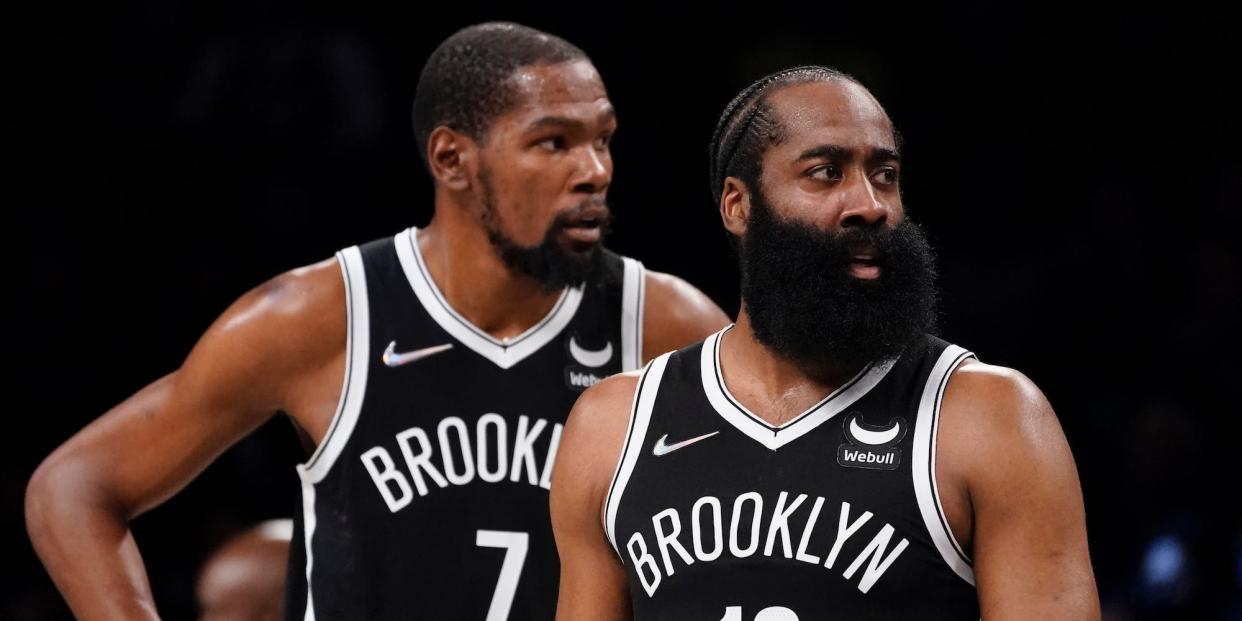 Kevin Durant stands by James Harden during a game.