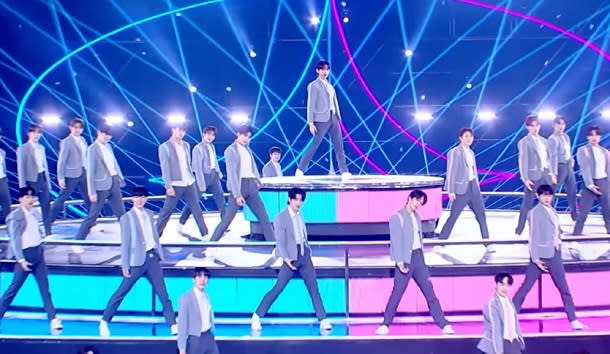 a group of boys pose while standing on a circular stage, in the korean show 'boys planet'