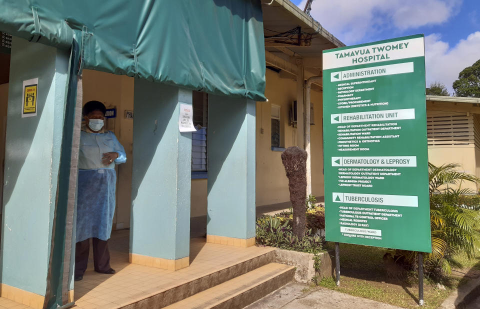 FILE - In this June 25, 2021, file photo, a nurse stands outside Tamara Twomey hospital during a growing coronavirus outbreak, in Suva, Fiji. Only four Pacific islands will be represented by their leaders and most will be forced to send smaller teams in at the forthcoming U.N. climate talks, known as COP26, in Glasgow because of COVID-19 travel restrictions. (AP Photo/Aileen Torres-Bennett, File)