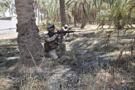 Members of the Iraqi security forces take their positions during a patrol in the town of Jurf al-Sakhar, south of Baghdad, July 16, 2014. Picture taken July 16 2014. REUTERS/Stringer