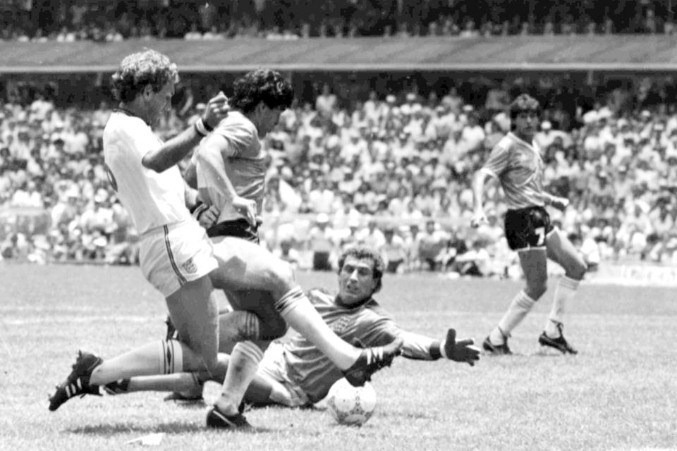 FILE - In this June 22, 1986 file photo, Argentina's Diego Maradona, second left, is about to score his second goal against England, during a World Cup quarterfinal soccer match against England, in Mexico City. England's Terry Butcher, left, tries to tackle Maradona, while England's goalkeeper Peter Shilton is on the ground. Gio Reyna, the son of former U.S. captain Claudio Reyna and women's national team midfielder Danielle Egan, was compared with Maradona in the '86 World Cup by U.S. coach Gregg Berhalter after a USA vs Mexico qualifying match in Mexico City on Thursday, March 24, 2022.(AP Photo/File)