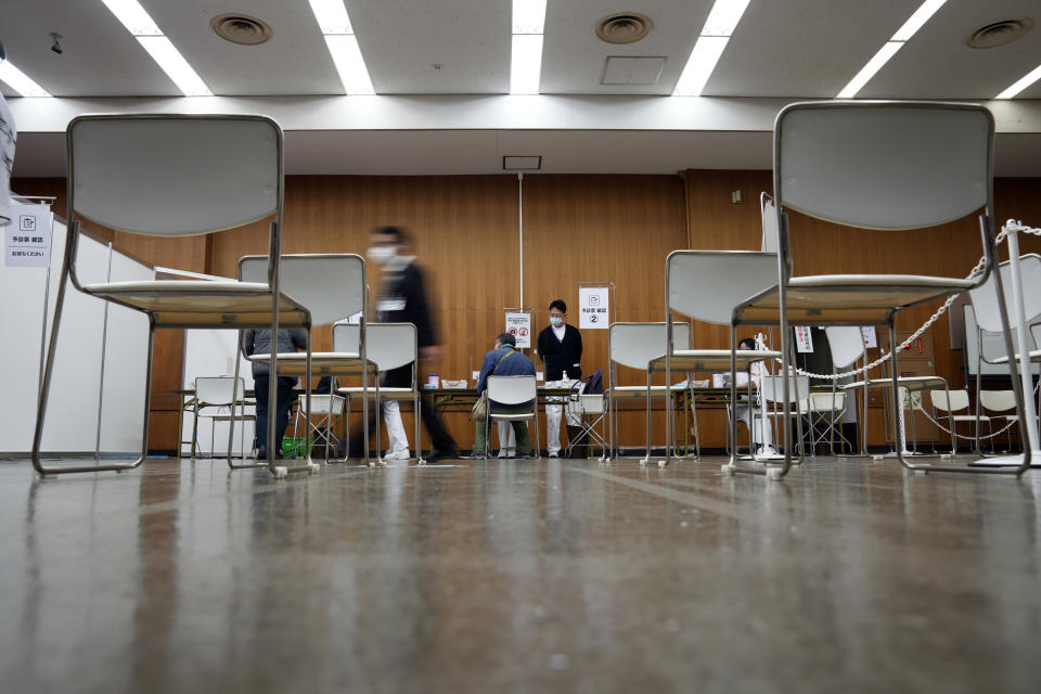 Local residents register to receive the booster shot of the Moderna coronavirus vaccine at a mass vaccination center operated by Japanese Self-Defense Force Monday, Jan. 31, 2022, in Tokyo. (AP Photo/Eugene Hoshiko, Pool)