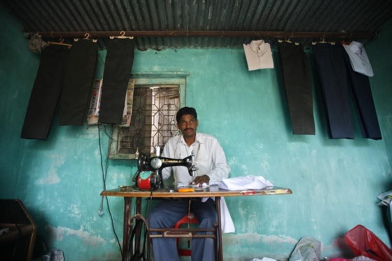 A tailor sews clothes at his shop in the Ralegan Siddhi village, located in the Ahmednagar district about 250km south east of Mumbai June 17, 2011. REUTERS/Danish Siddiqui/Files