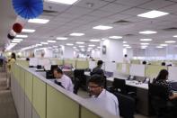 A man works in a cubicle at Deloitte's office in Gurugram