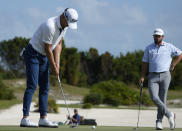 Justin Thomas, of the United States, left, hits for par at the third green as Cameron Young, of the United States, looks on during the final round of the Hero World Challenge PGA Tour at the Albany Golf Club in New Providence, Bahamas, Sunday, Dec. 4, 2022. (AP Photo/Fernando Llano)