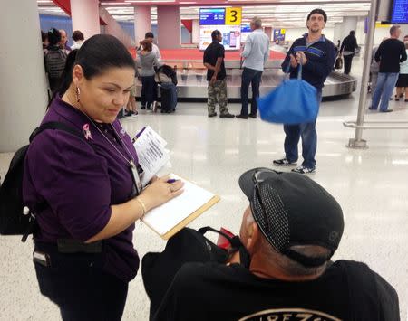 Emily Pagan, a New York state government official, greets and help orients people arriving from Puerto Rico and the U.S. Virgin Islands at John F. Kennedy International Airport in New York, U.S. October 19, 2017. Photo taken October 19, 2017. REUTERS/Jonathan Allen