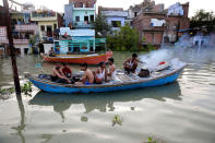 <p>Flood affected people cook food in a boat in front of submerged homes in Allahabad, India, Thursday, Aug. 25, 2016. (AP Photo/Rajesh Kumar Singh)</p>