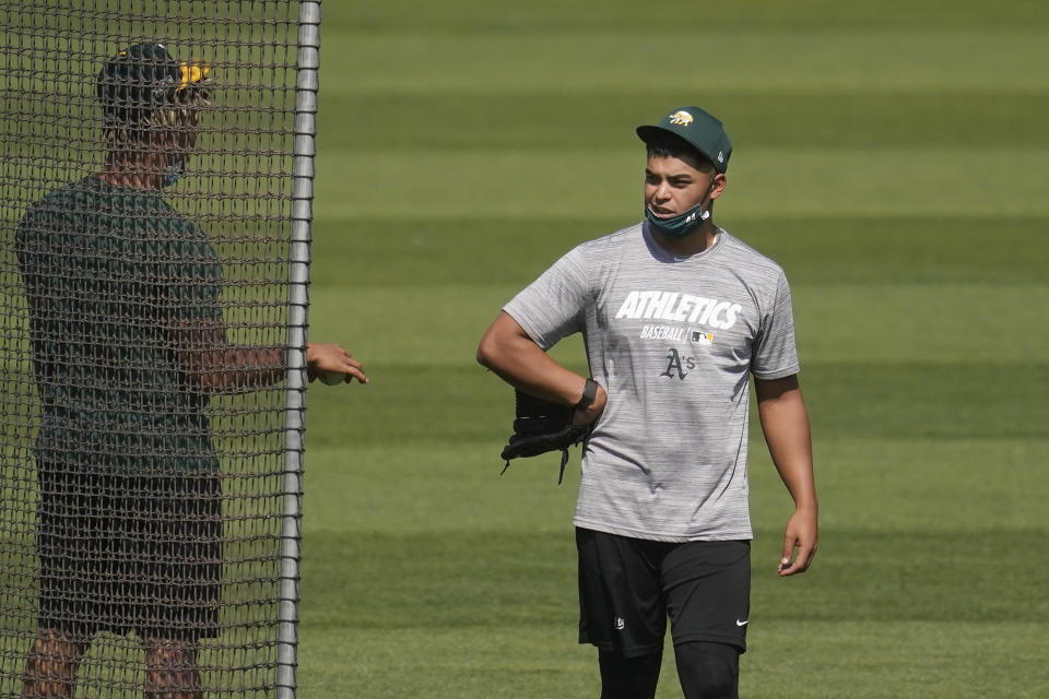 Oakland Athletics pitcher Jesus Luzardo, right, talks with Frankie Montas during a baseball workout in Oakland, Calif., Monday, Sept. 28, 2020. The Athletics are scheduled to play the Chicago White Sox in an American League wild-card playoff series starting Tuesday. (AP Photo/Jeff Chiu)