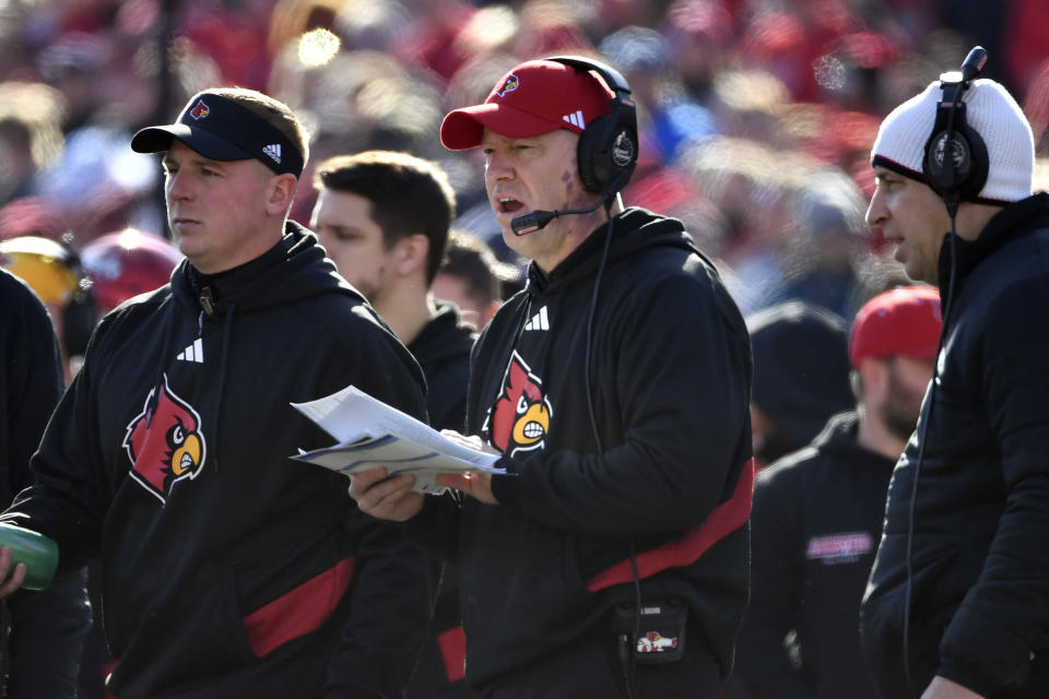 Louisville head coach Jeff Brohm goes over his list of plays during the second half of an NCAA college football game against Kentucky in Louisville, Ky., Saturday, Nov. 25, 2023. Kentucky won 38-31. (AP Photo/Timothy D. Easley)