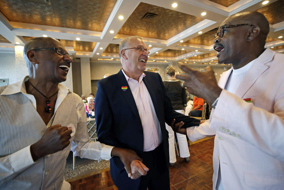 In this June 7, 2019, photo, Boston Pride Parade grand marshal Dale Mitchell, middle, reminisces with Charles Evans, left, and Paul Glass at a Pride event in Boston. All three men were at The Stonewall Inn when riots broke out between gays and police 50 years earlier in New York's Greenwich Village. (AP Photo/Elise Amendola)