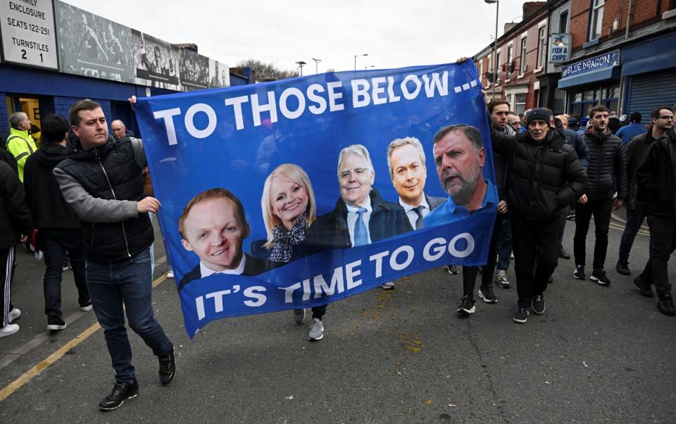 Everton fans protest hold a banner reading "It's time to go..." with portraits of club owner Farhad Moshiri (2ndR) and board members (from L) Grant Ingles, Denise Barrett-Baxendale, Bill Kenwright and Graeme Sharp