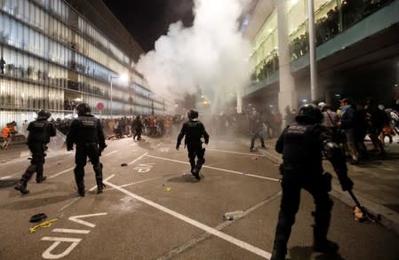 Protesters clash with police officers as they demonstrate at the airport, after a verdict in a trial over a banned independence referendum, in Barcelona