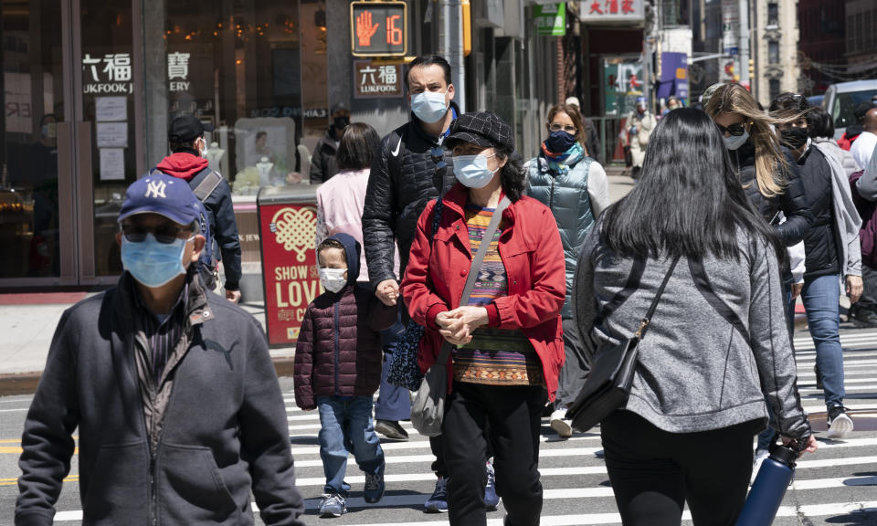 People walk on the street on April 26, 2021 in New York. (Mark Lennihan/AP)