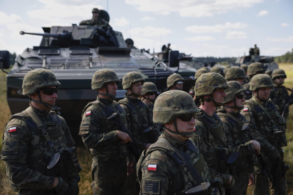 Polish servicemen attend a press conference of Poland's Minister of Defense, Mariusz Blaszczak, in Jarylowka, Poland, Saturday, Aug. 12, 2023. Minister Mariusz Blaszczak on Saturday met in Jarylowka with some of the troops recently deployed with their defense equipment close to the Belarus border. (AP Photo/Michal Dyjuk)