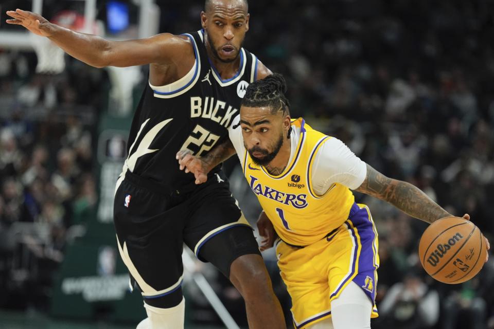 Los Angeles Lakers' D'Angelo Russell gets past Milwaukee Bucks' Khris Middleton during the first half of an NBA basketball game Tuesday, March 26, 2024, in Milwaukee. (AP Photo/Morry Gash)