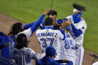 Toronto Blue Jays' Alejandro Kirk (85) is mobbed by teammates Vladimir Guerrero Jr., left, Teoscar Hernández (37) and Lourdes Gurriel Jr., right, after hitting a solo home run against the New York Yankees during the seventh inning of a baseball game in Buffalo, N.Y., Monday, Sept. 21, 2020. (AP Photo/Adrian Kraus)