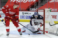 CORRECTS DETROIT PLAYER TO DYLAN LARKIN, INSTEAD OF FILIP ZADINA - Columbus Blue Jackets goaltender Elvis Merzlikins (90) stops a shot by Detroit Red Wings center Dylan Larkin (71) during the second period of an NHL hockey game Tuesday, Jan. 19, 2021, in Detroit. (AP Photo/Duane Burleson)