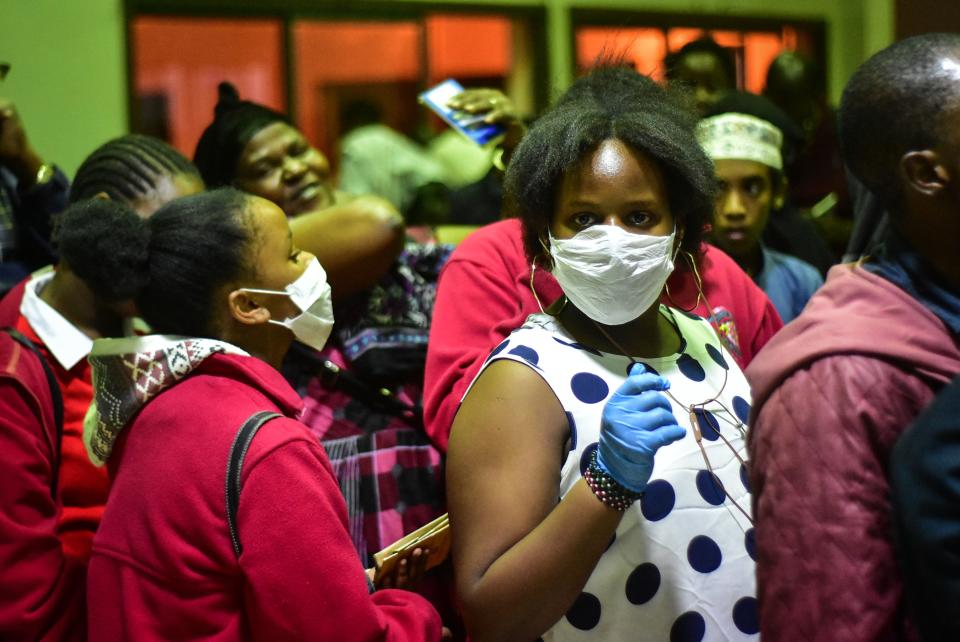 Travellers wearing face masks as protective measure wait to get their temperature checked at the border post with Kenya in Namanga, northern Tanzania, on March 16, 2020, on the day Tanzania confirmed the first case of the covid-19. - Tanzania and Somalia on March 16 became the latest East African countries to confirm their first cases of coronavirus, as neighbouring countries shuttered borders and schools as fears of contagion rose. A 46-year-old Tanzanian woman tested positive for the illness after returning from Belgium on March 15, where she had been staying with a relative sick with coronavirus. (Photo by Filbert RWEYEMAMU / AFP) (Photo by FILBERT RWEYEMAMU/AFP via Getty Images)