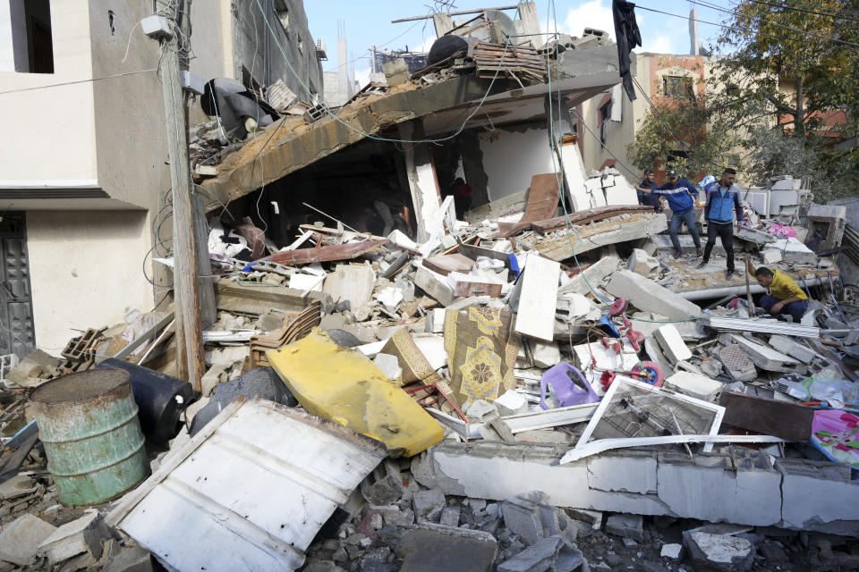 Palestinians search for the bodies of the Darwesh family killed in the Israeli bombardment of the Gaza Strip in Nusseirat refugee camp, central Gaza Strip, Tuesday, Jan. 2, 2024. (AP Photo/Adel Hana)