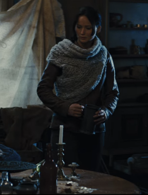 I love the weird torso scarf because it's a subtle but effective indication of Katniss's new social status as a Victor. She still has her Dad's leather jacket on underneath it, but the extra accessory, though practical rather than purely ornamental, is a luxury she wouldn't have had access to in the first film. Also, I want one. Weird torso scarves for everyone, please and thank you. 