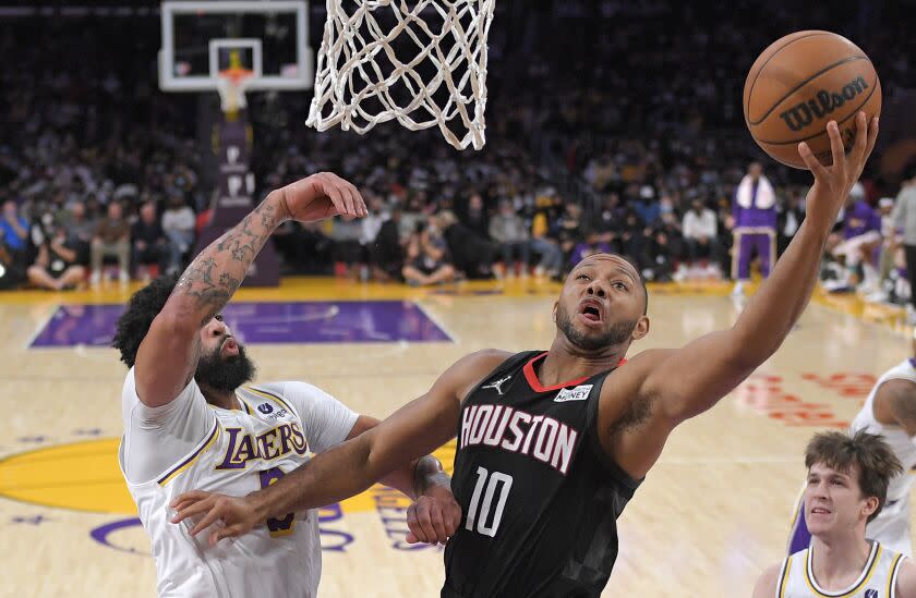 Houston Rockets guard Eric Gordon, right, shoots as Los Angeles Lakers forward Anthony Davis defends during the first half of an NBA basketball game Sunday, Oct. 31, 2021, in Los Angeles. (AP Photo/Mark J. Terrill)