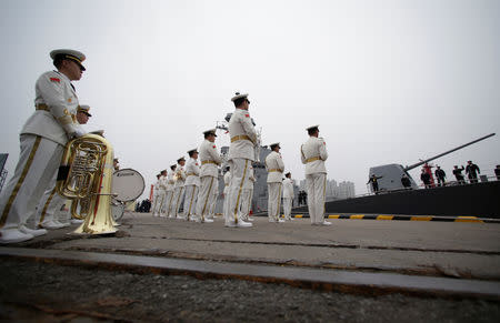 A Chinese military band welcomes the Japan Maritime Self-Defense Force destroyer JS Suzutsuki (DD 117) as it arrives at Qingdao Port for the 70th anniversary celebrations of the founding of the Chinese People's Liberation Army Navy (PLAN), in Qingdao, China April 21, 2019. REUTERS/Jason Lee