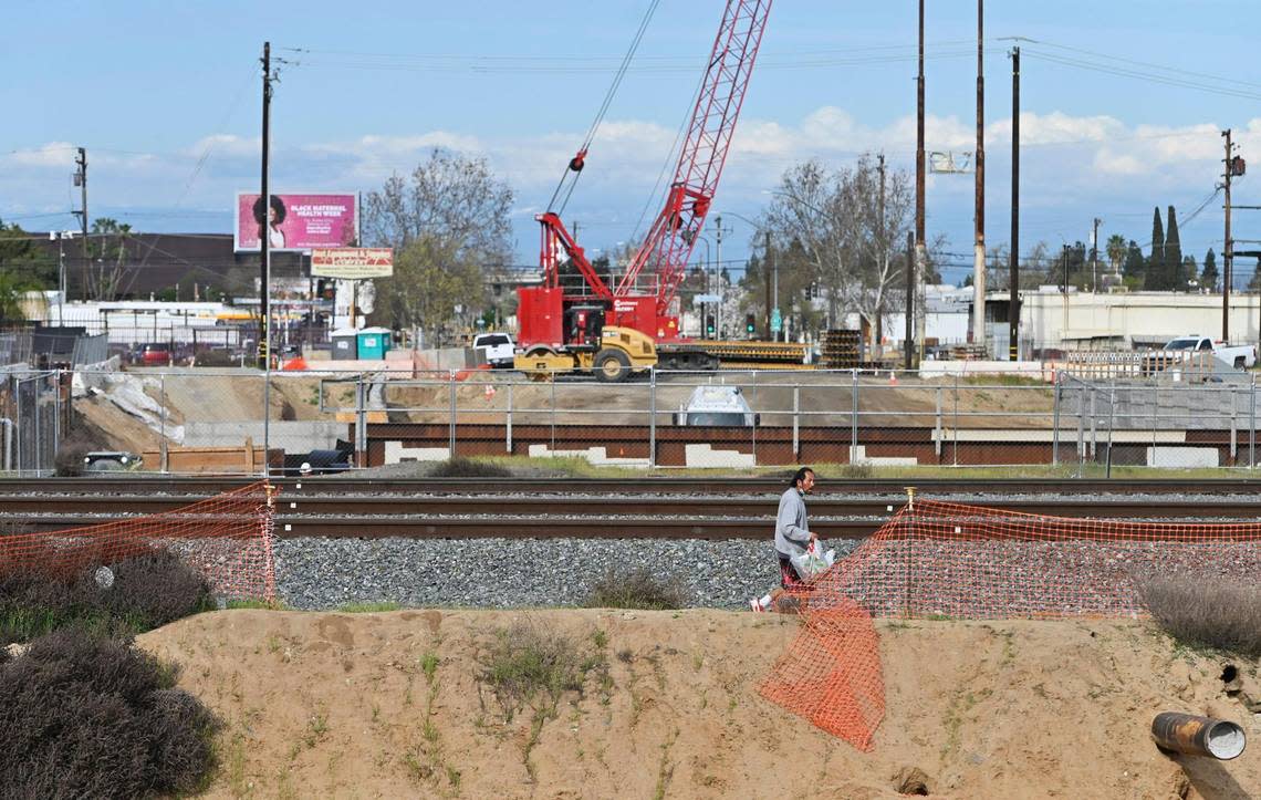 A man walks above the High Speed Rail underpass at Ventura Street, Thursday, Mar. 21, 2024 in Fresno.