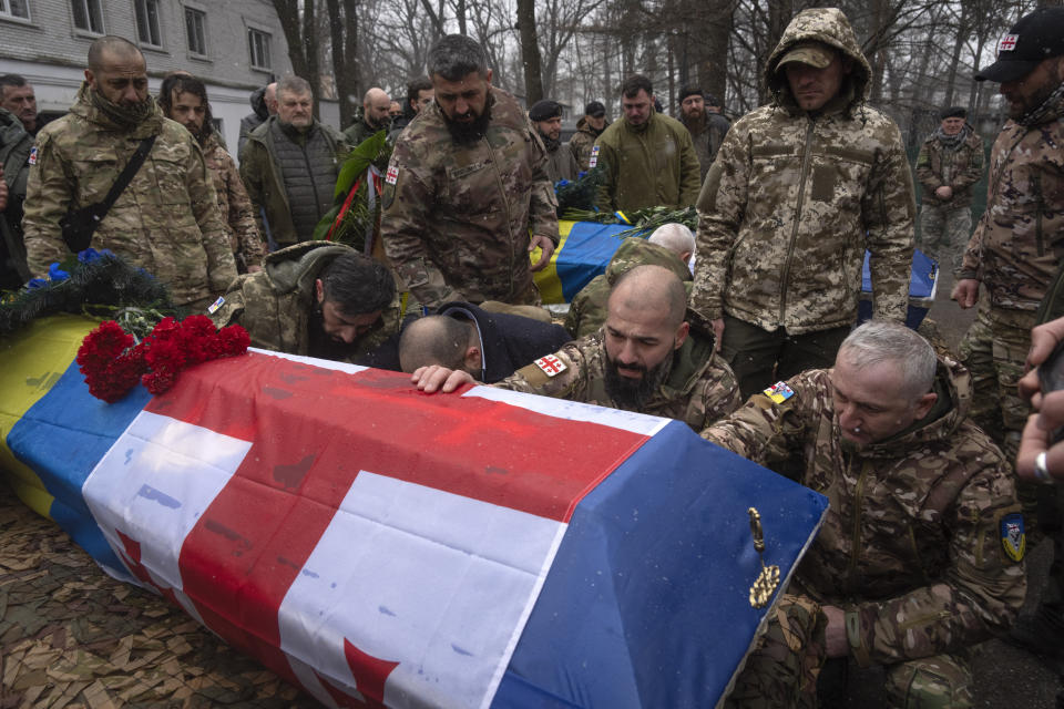 Volunteers of the Georgian legion pay last respects at the coffins of their comrades Nodar Nasirov, 28, and Georgia Gogilashvili, 40, who were killed in a battle against Russian troops, during a funeral ceremony in Kyiv, Ukraine, Tuesday, March 12, 2024. The Georgian legion is a military unit formed mainly by ethnic Georgian volunteers. (AP Photo/Efrem Lukatsky)