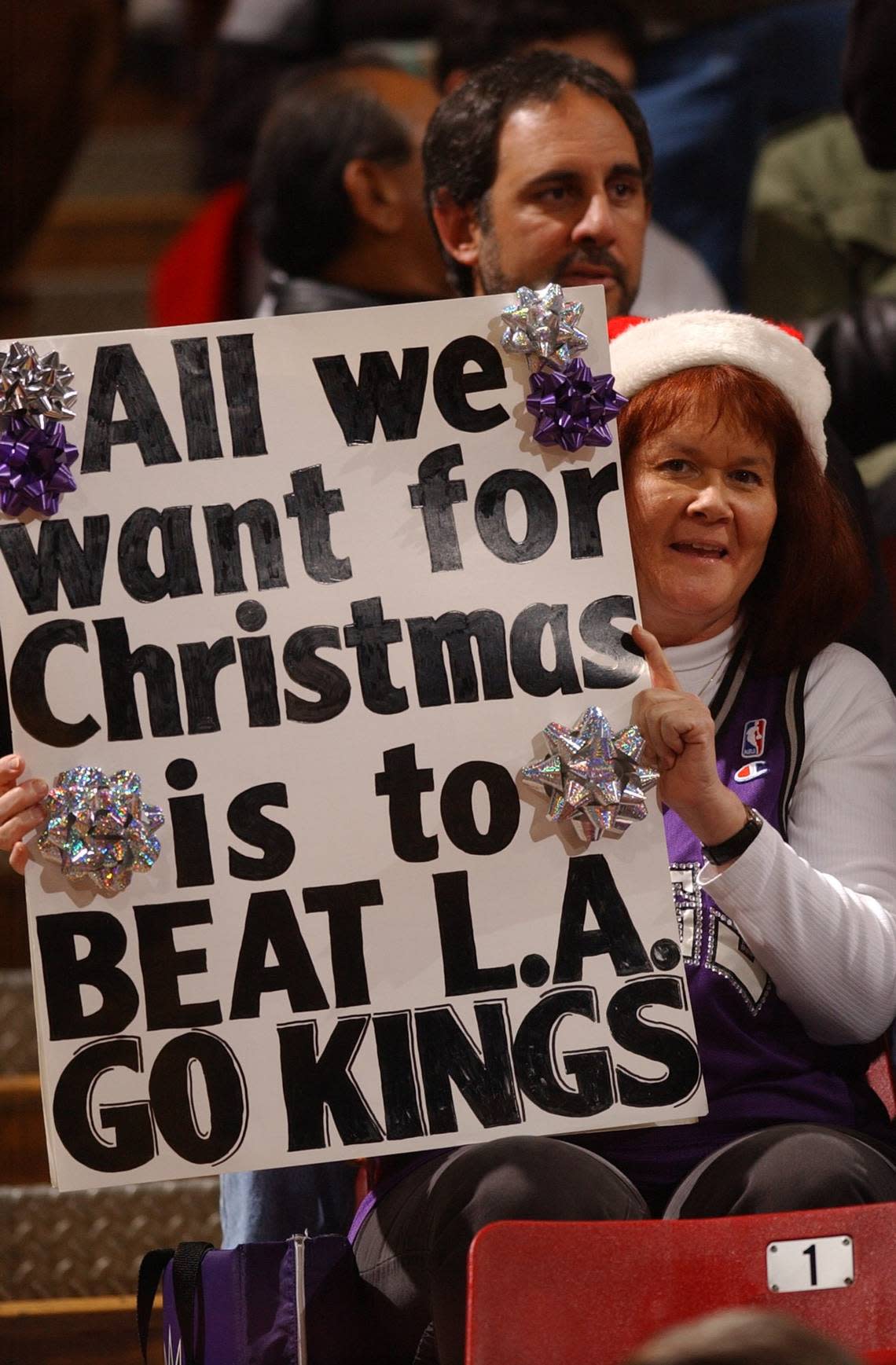 Sacramento Kings fan Barbara Rust, of Folsom, shows the Kings players her Christmas wish in 2002 at Arco Arena. Hector Amezcua/Sacramento Bee file